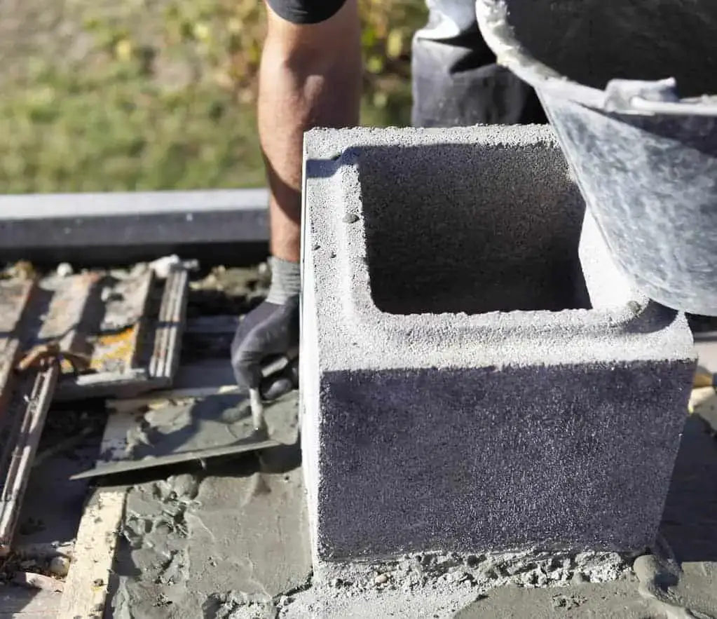 Self-made chute for concreting works. Concrete pours down a wooden